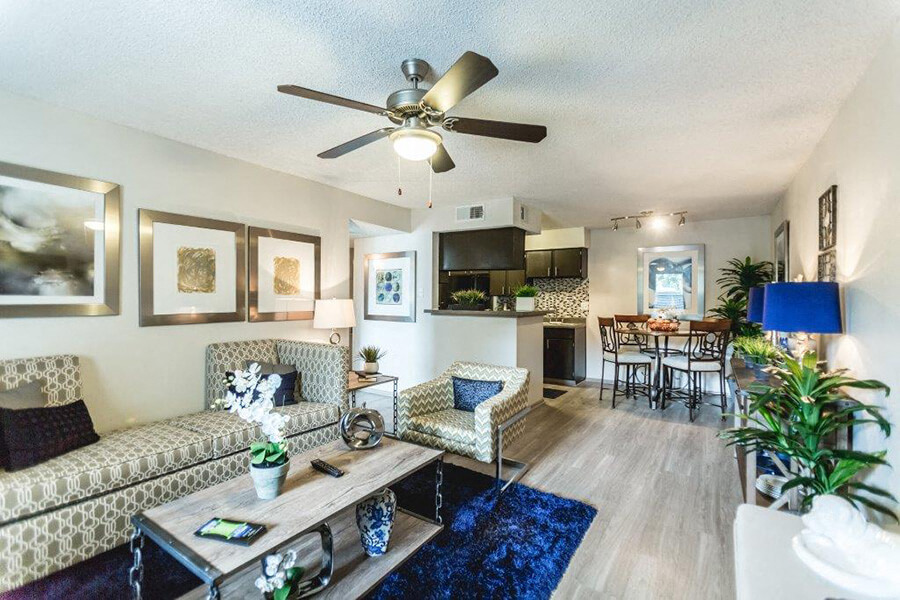 a living room with furniture and a ceiling fan