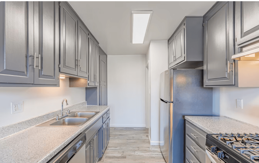 a kitchen with gray cabinets and white countertops