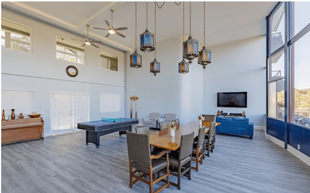 a large room with a ping pong table and a flat screen tv