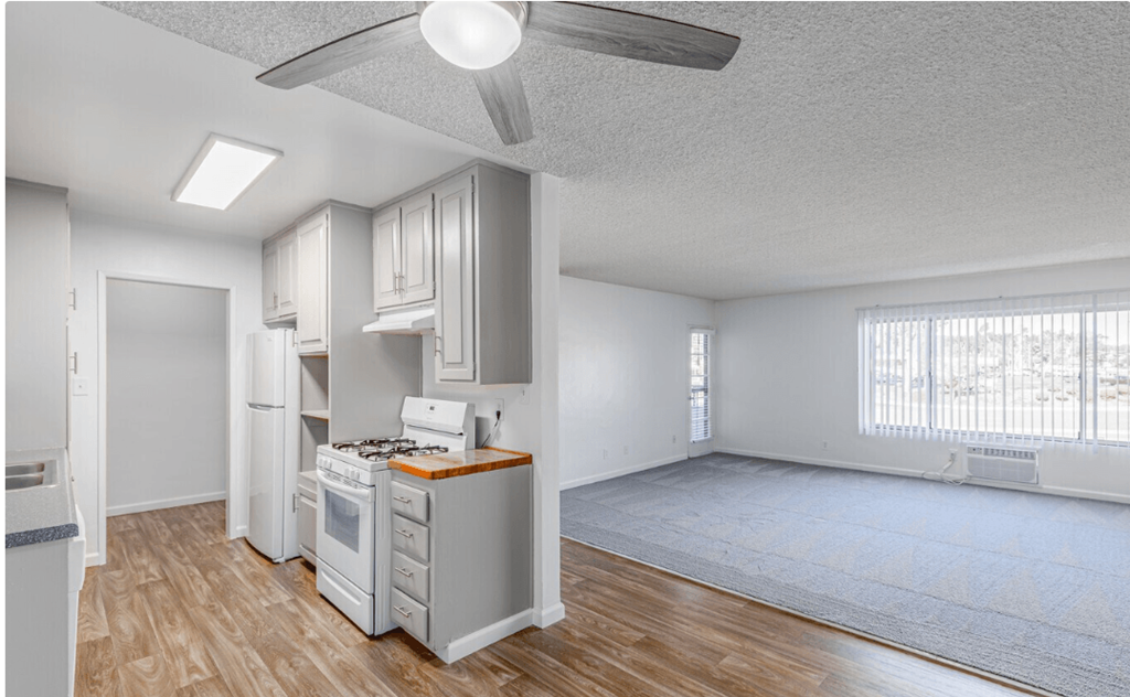 an empty living room with a ceiling fan