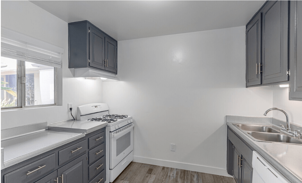 a kitchen with gray cabinets and white appliances