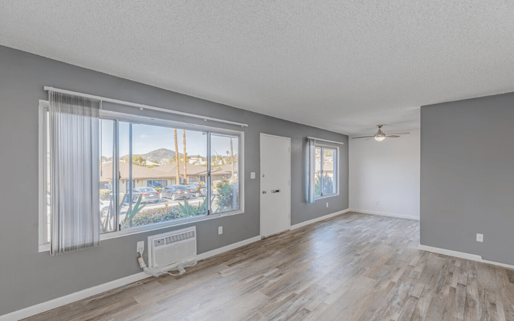 Dog Friendly Apartments in El Cajon CA - Ivanhoe Village - Unfurnished Open-Concept Living Room with Large Window and Sliding Glass Door to Patio