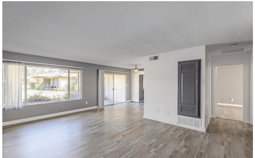 a living room with hardwood floors and grey walls