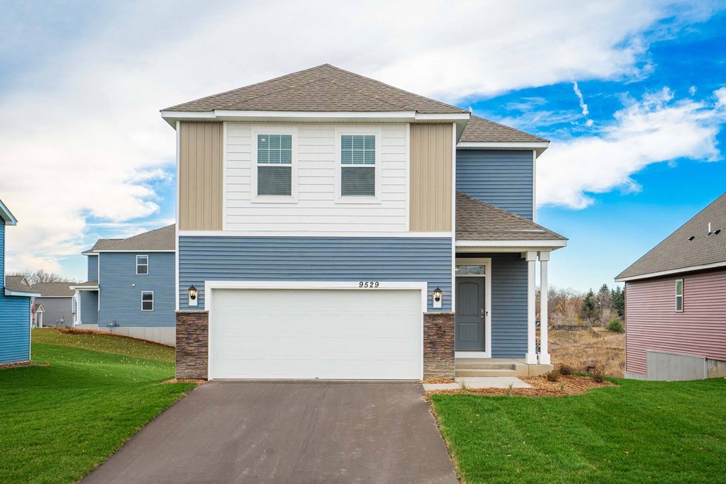 a blue and tan house with a garage door
