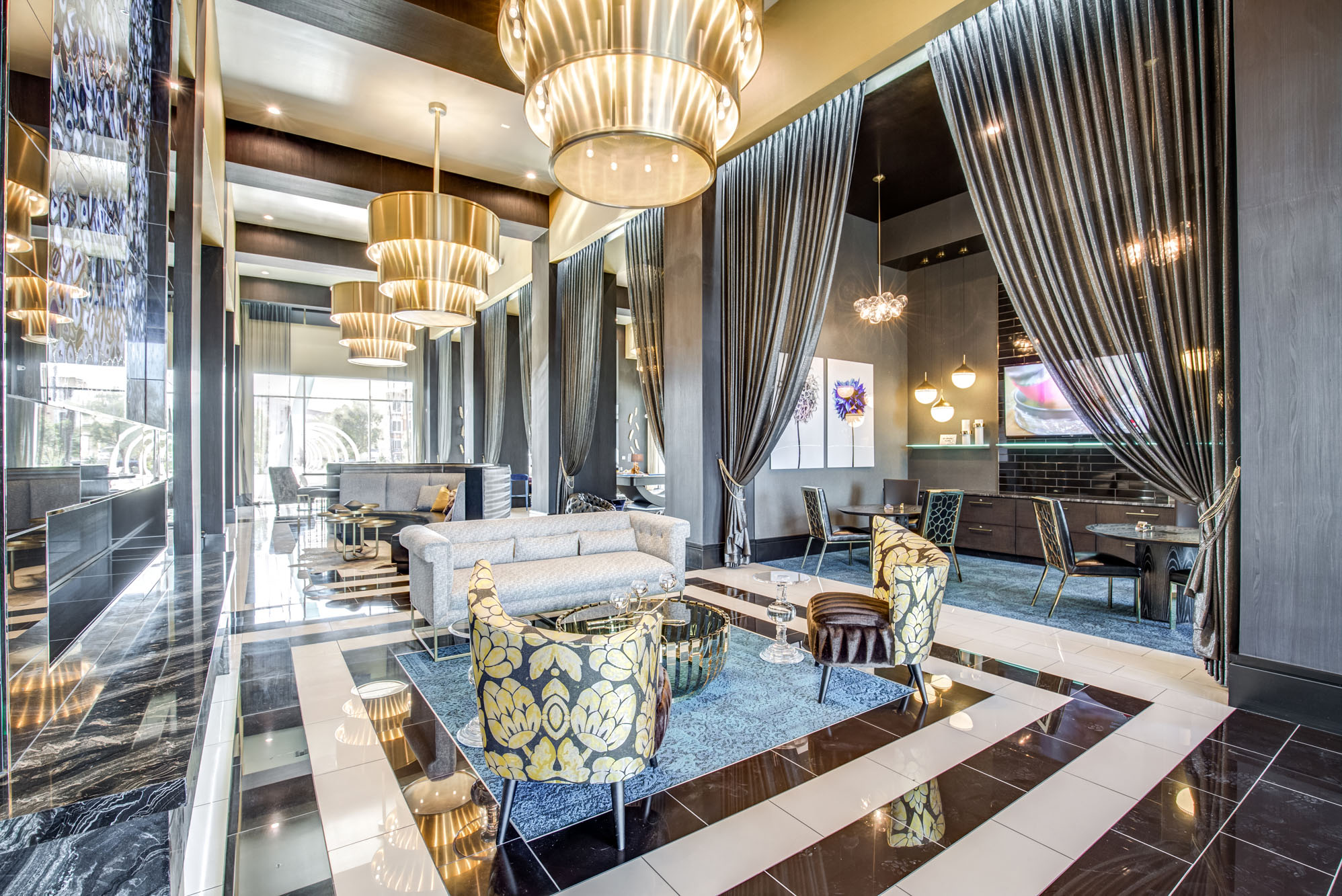 a lobby with couches and chairs and chandeliers