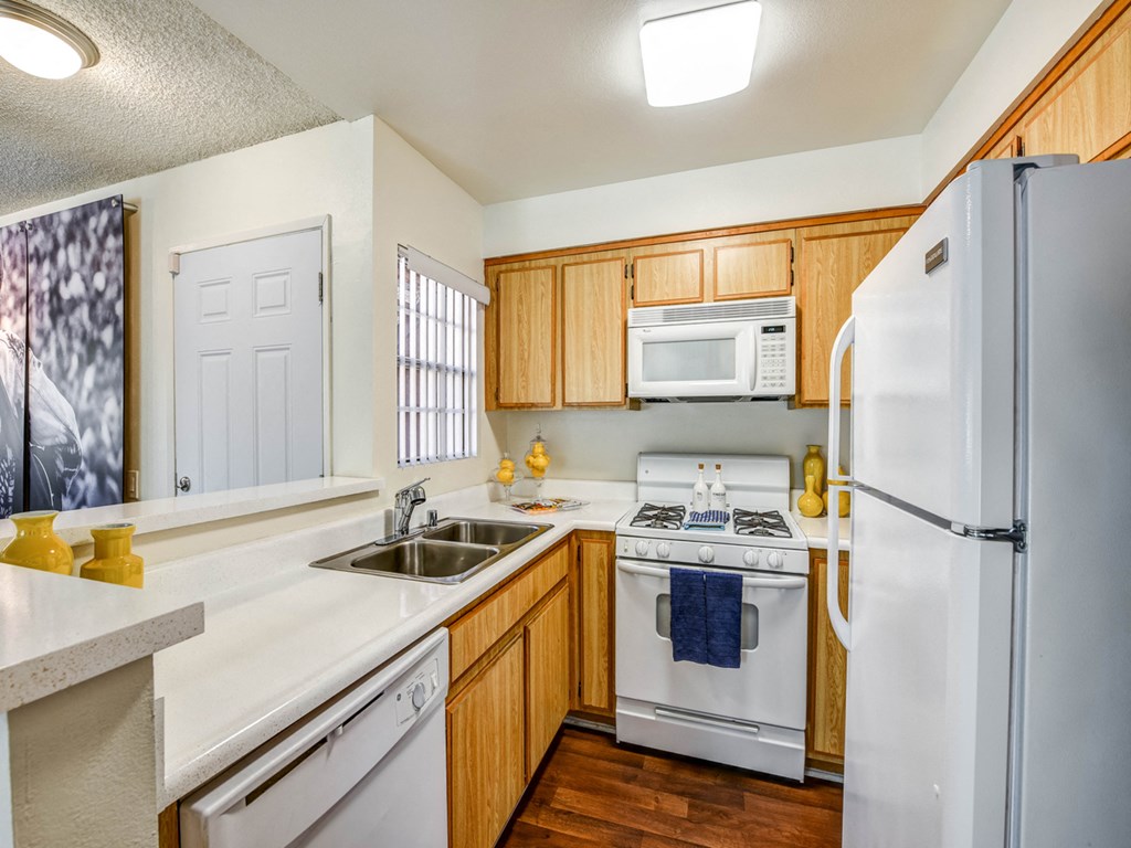 a kitchen with white appliances and wooden cabinets