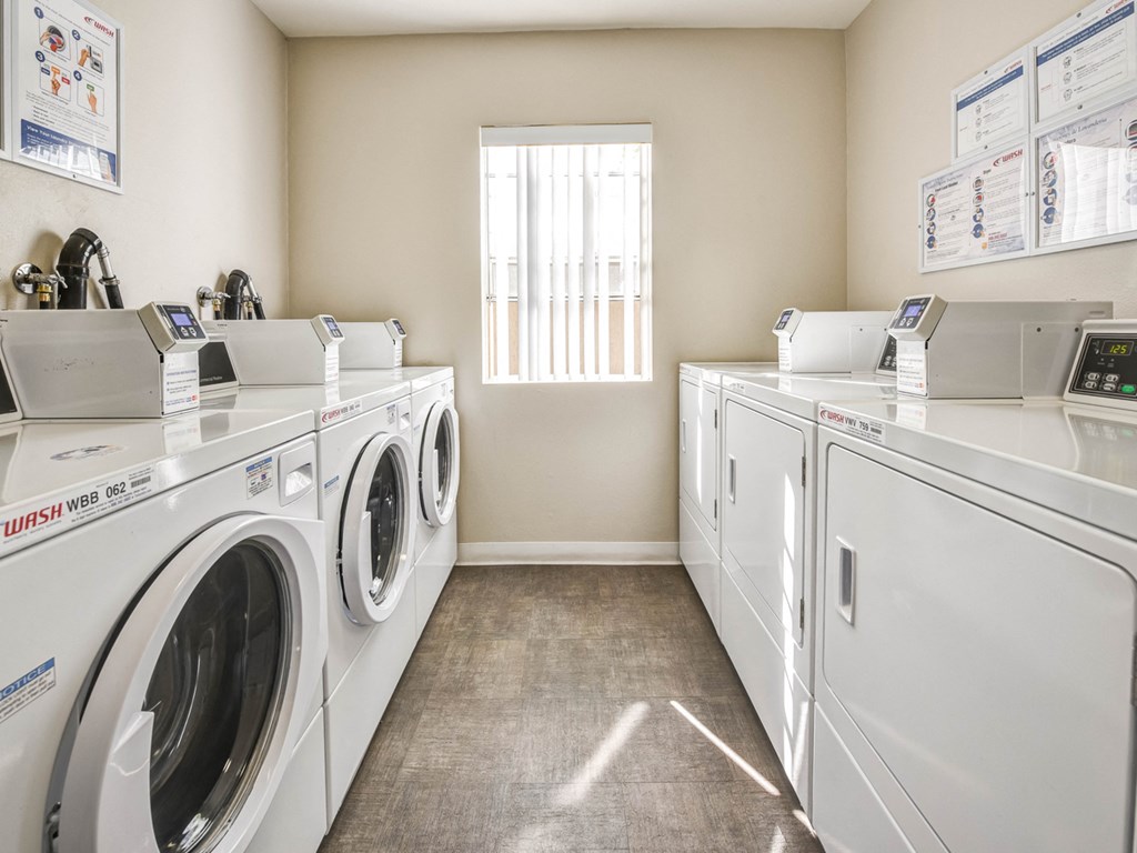 a laundry room with washes and dryers and a window