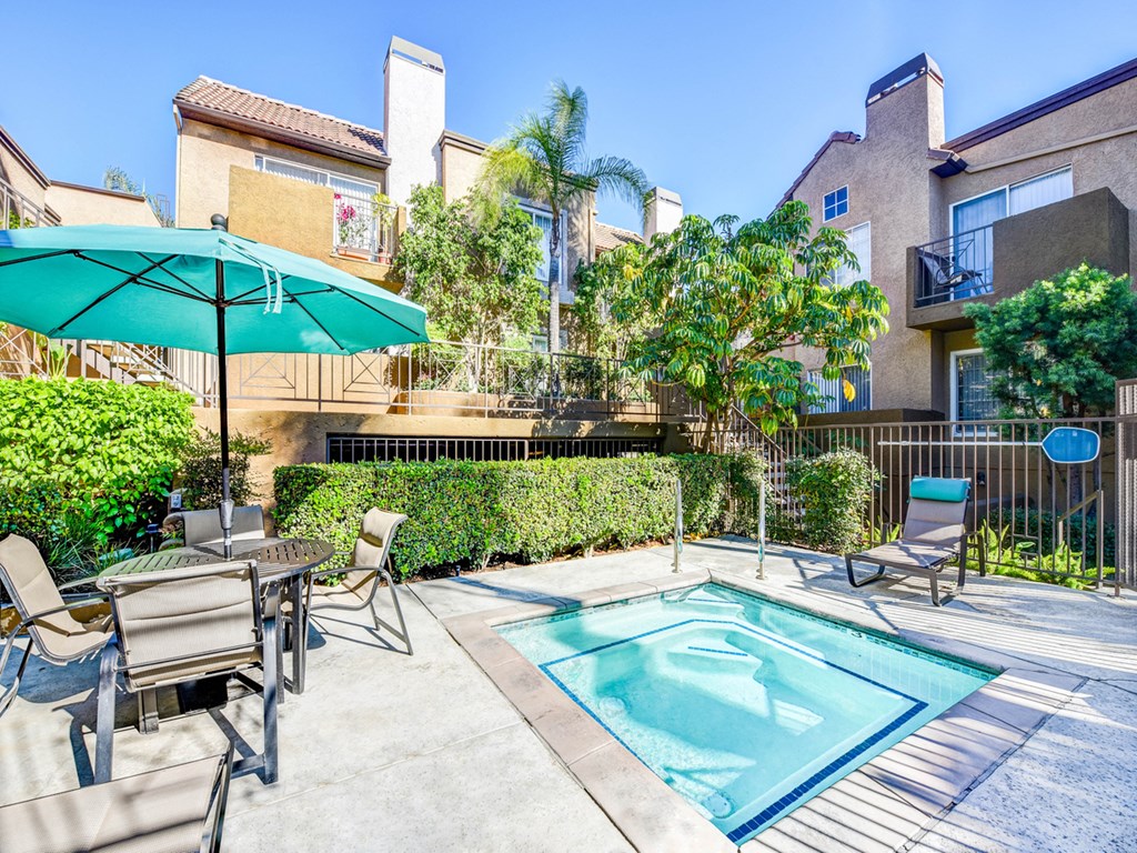 our apartments have a pool and a patio with chairs and umbrellas