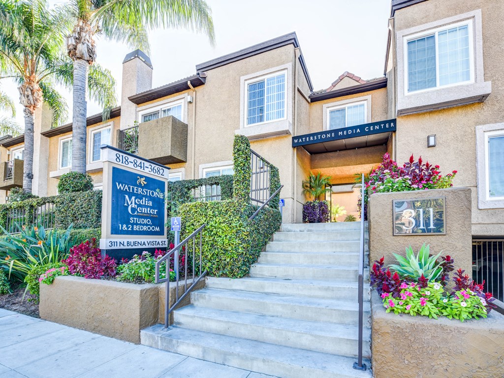 a building with stairs and a sign in front of it