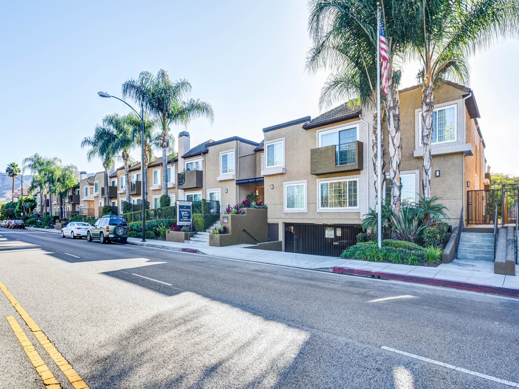 a row of houses with palm trees on a city street