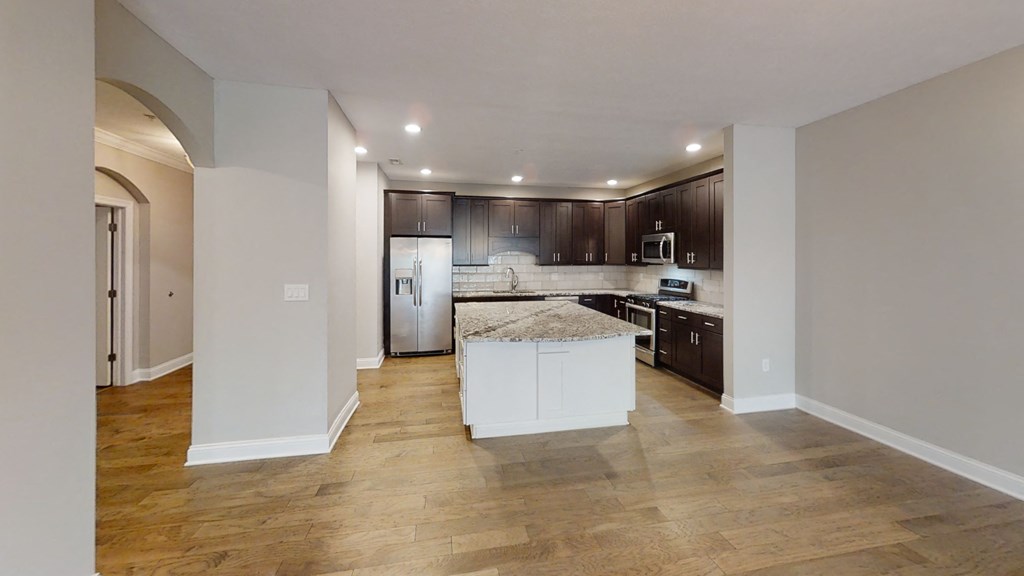 a kitchen with a large center island with a granite countertop