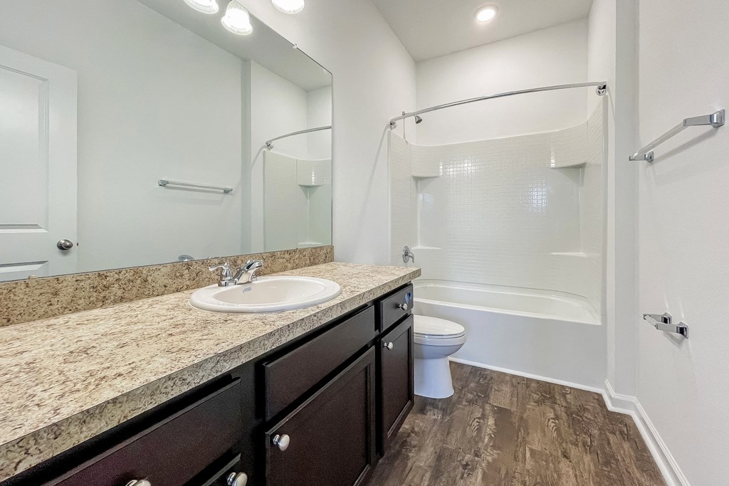A bathroom with a sink, toilet, and shower.