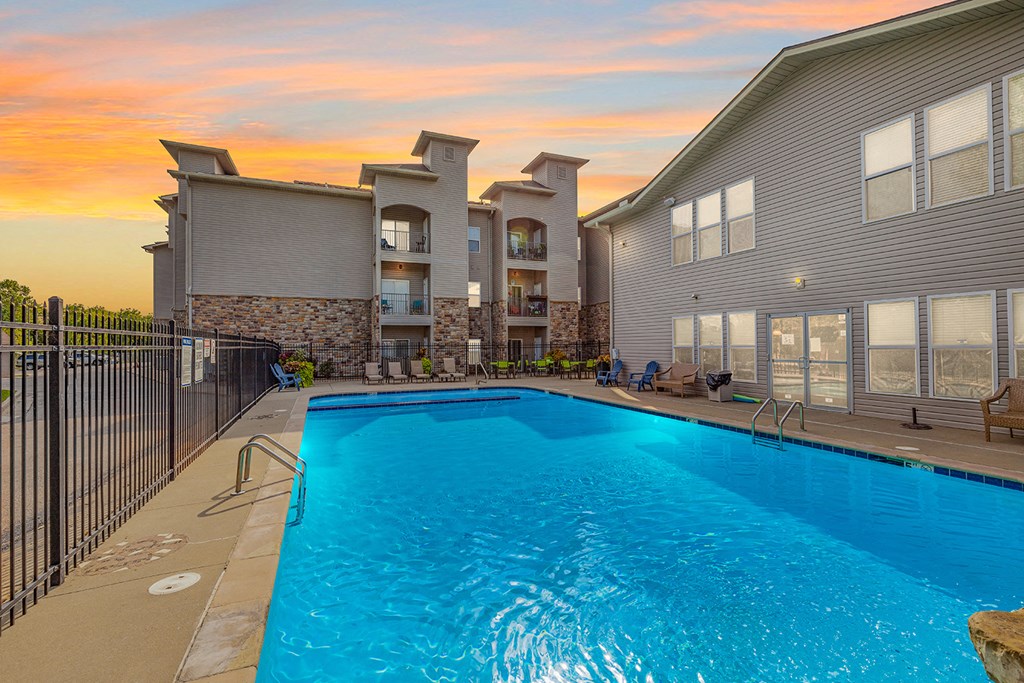 our apartments have a large swimming pool with a sunset in the background