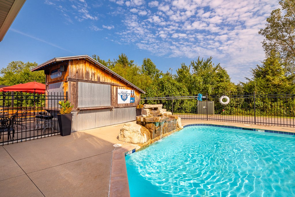 the pool is heated and has a bar and a water feature