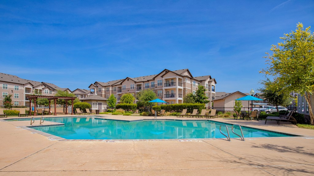 Giant Swimming pool beach chairs and building in background