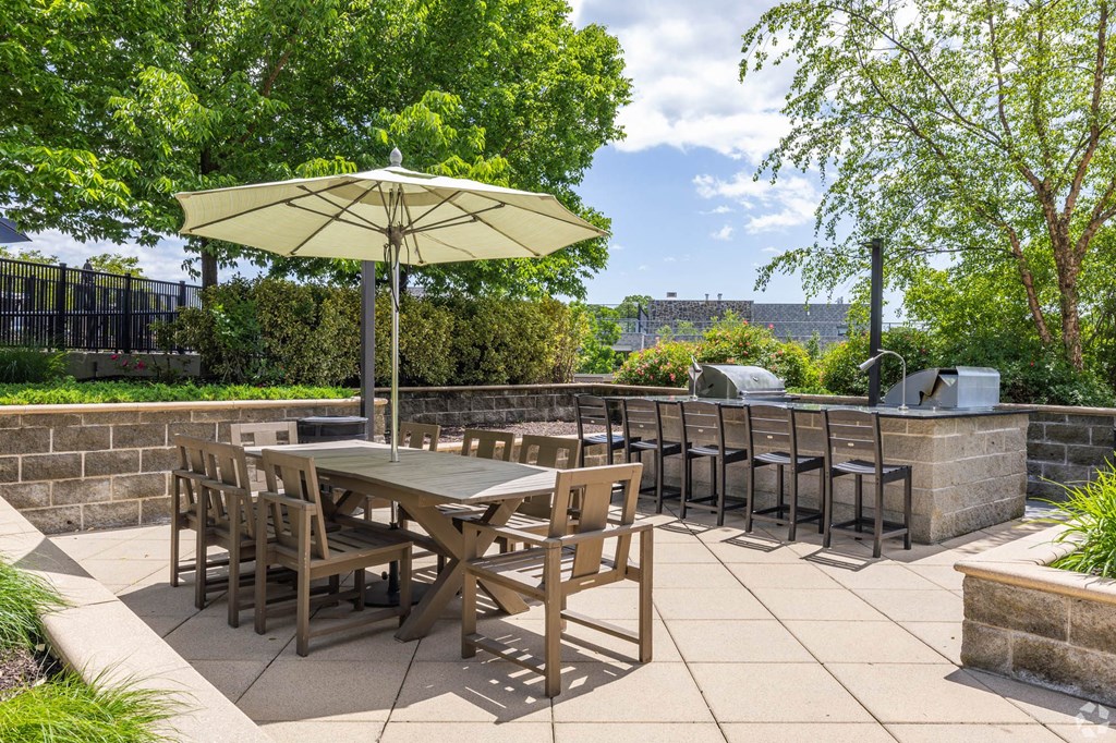 a patio with tables and chairs and an umbrella