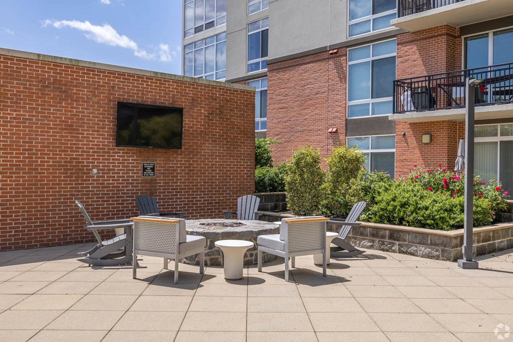 a patio with a table and chairs in front of a building