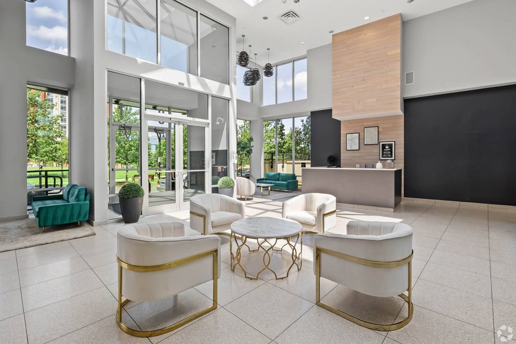 the lobby or reception area of a hotel with chairs and tables
