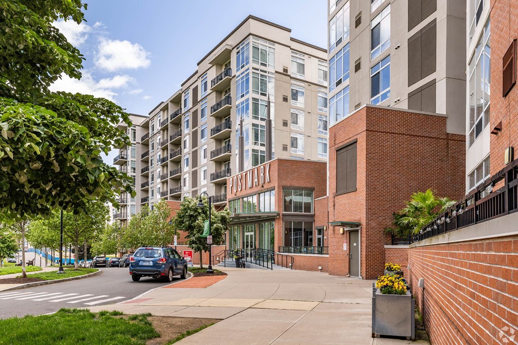 a car driving past an apartment building on a city street