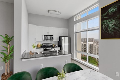 a kitchen with a large window and a table with green chairs