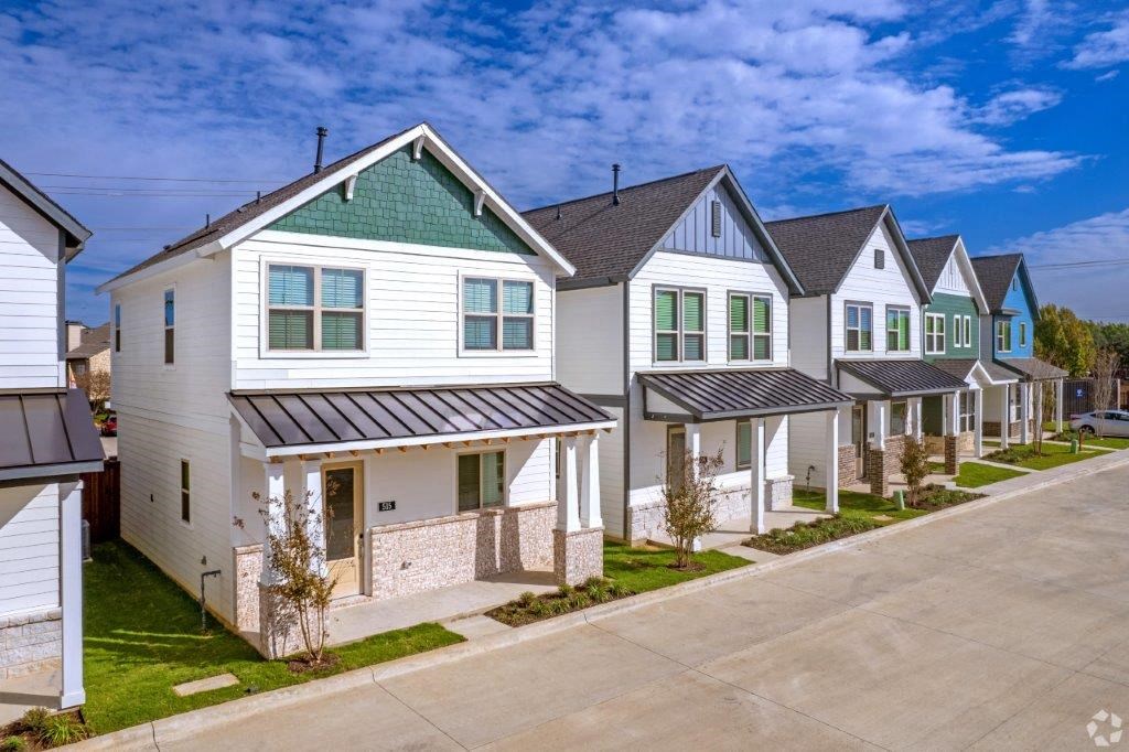 a row of white houses with green shutters
