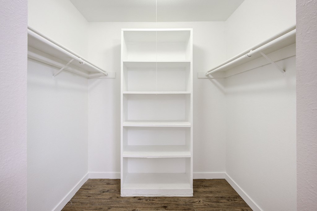a small walk in closet with empty shelves