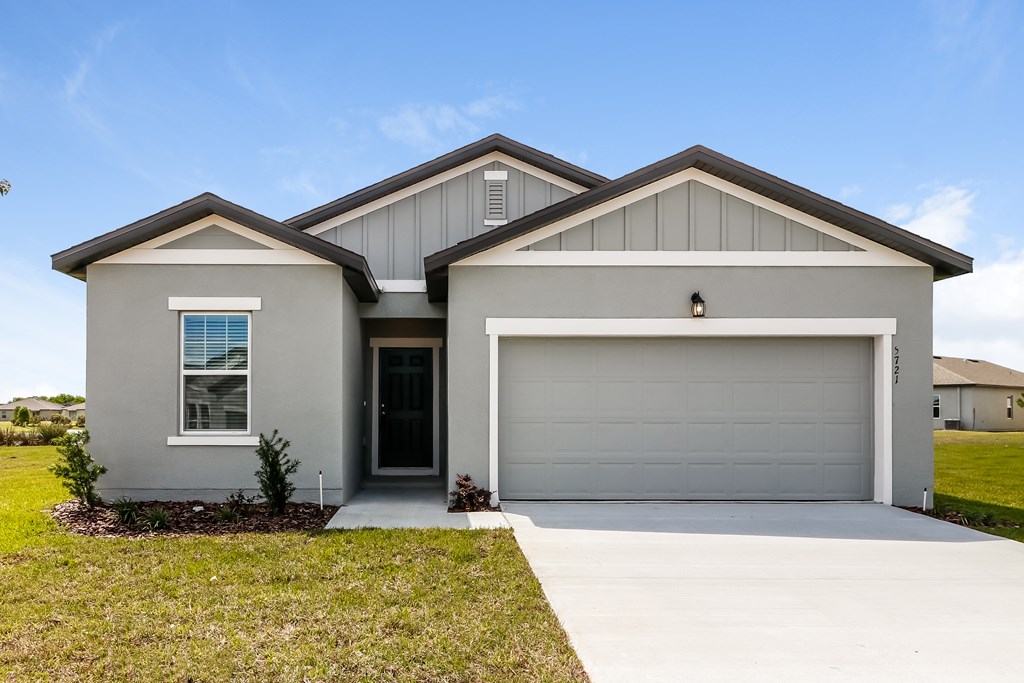 A two-story house with a garage door and a window.