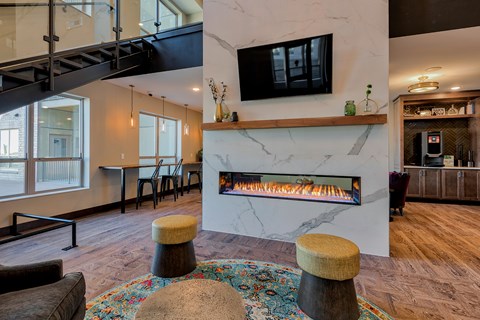 A living room with a fireplace and a television mounted above it.