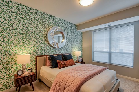 A bedroom with a bed, nightstands, and a mirror.