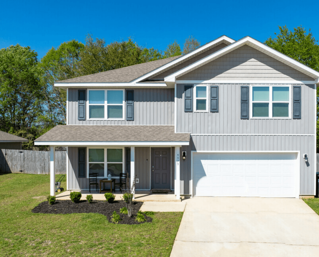 a gray house with a white garage door and a lawn