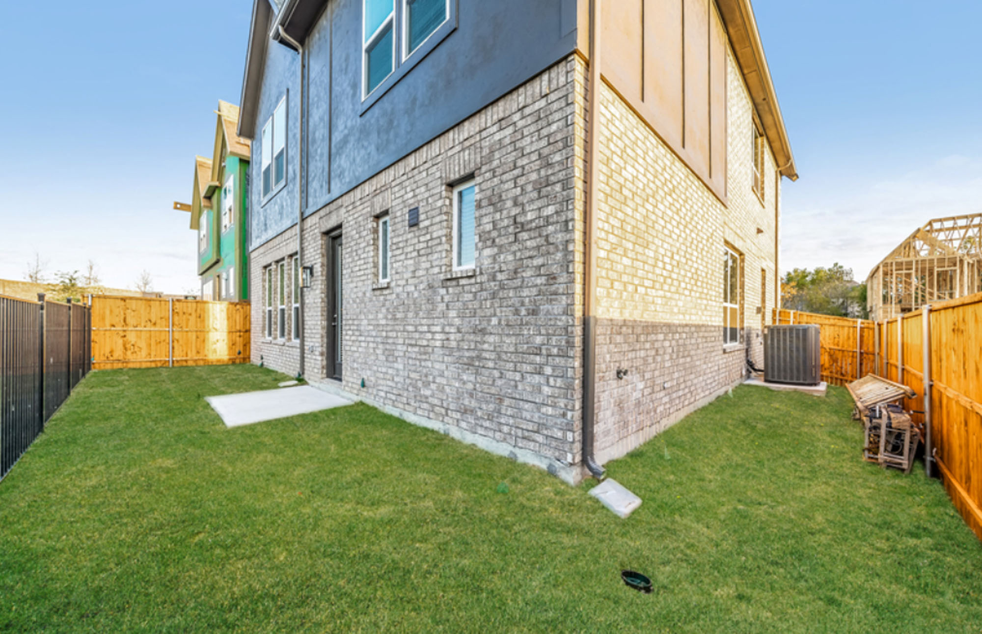 Homes For Rent In Allen, TX - Ridgeview Villas - Exterior View Of A Backyard With A Wooden And Black Fence And Grass