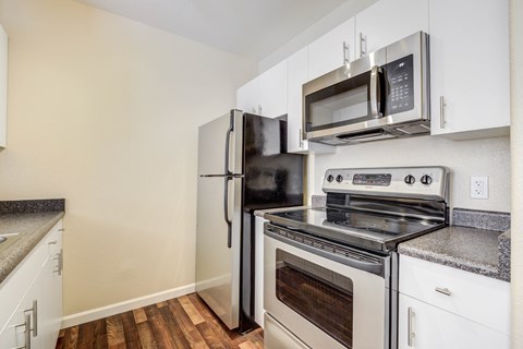 a kitchen with white appliances and a refrigerator and microwave