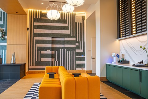 A modern living room with a yellow sofa and a striped wall.