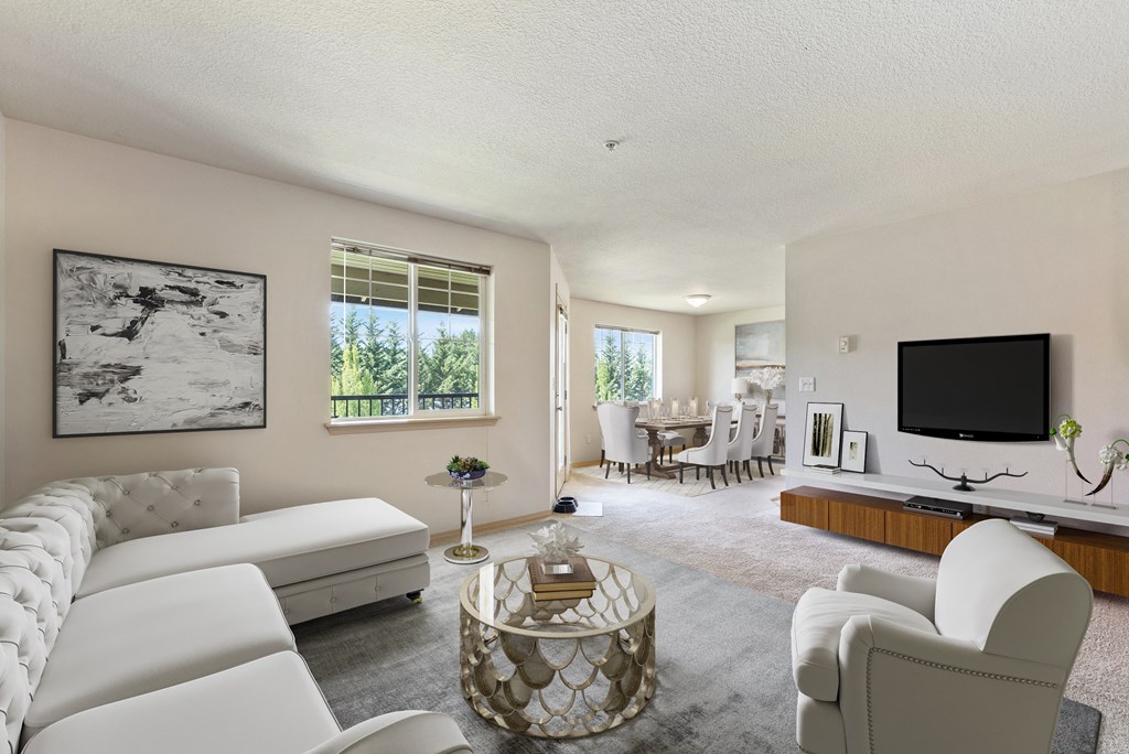 a living room with white couches and chairs and a television