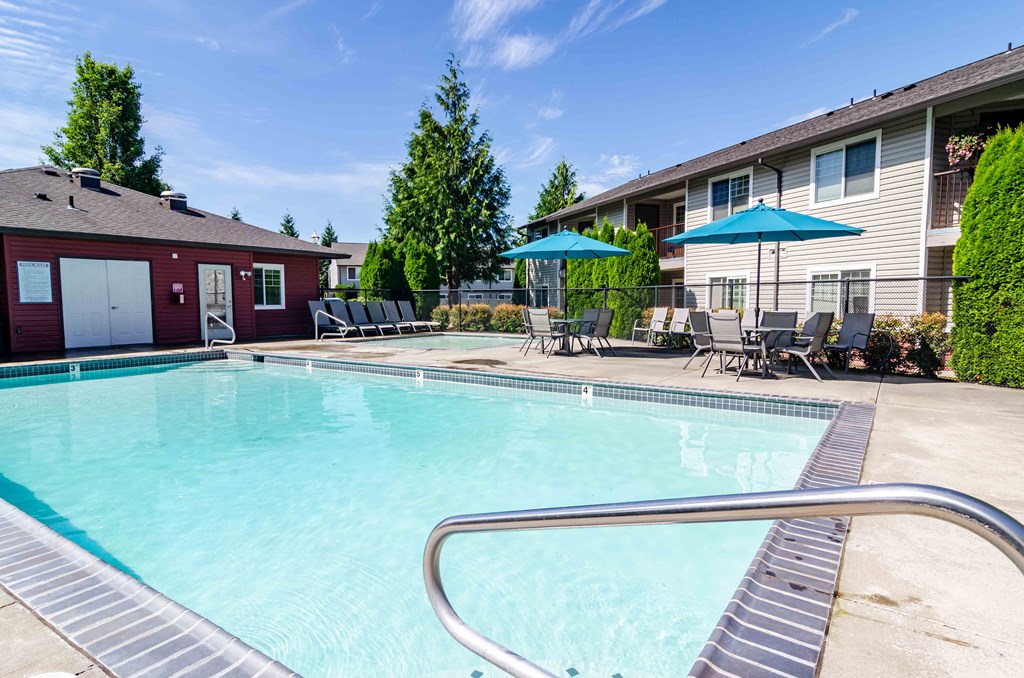 1-Bedroom Apartments in Vancouver, WA - Reflections at the Park - Sparkling Swimming Pool with Wading Pool, Daybeds, Tables, Chairs, And Umbrellas
