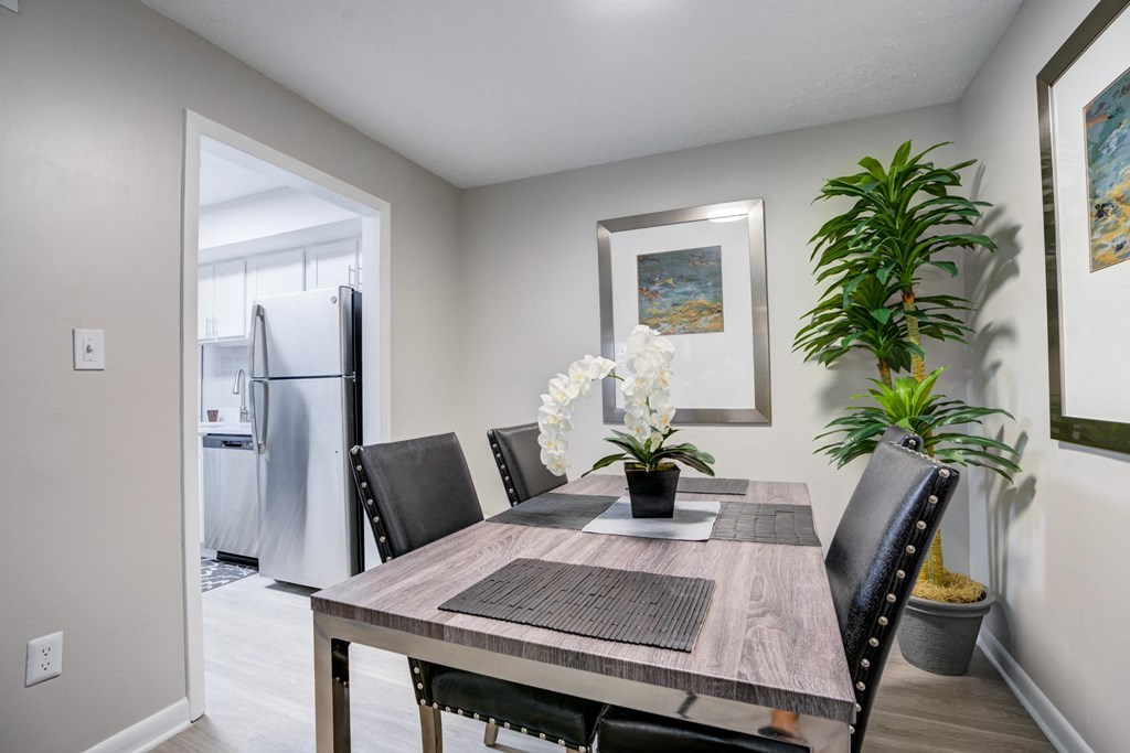 a dining room with a table and chairs and a refrigerator