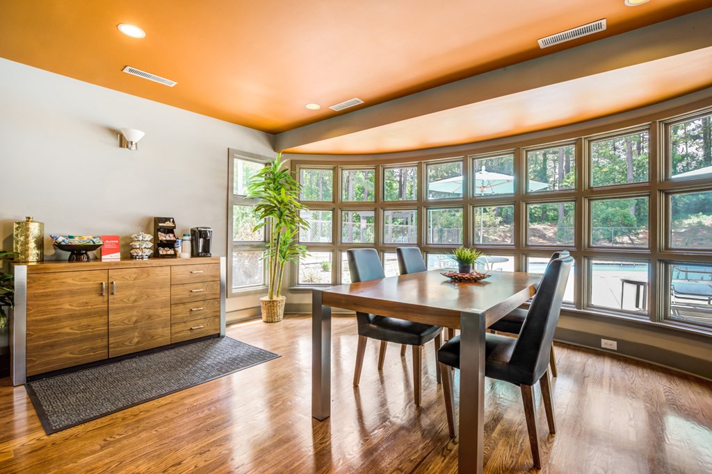 a dining room with a table and chairs and windows