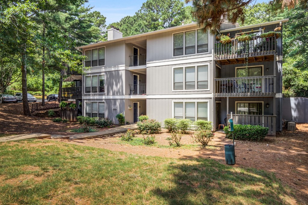 the view of an apartment building with a lawn and trees