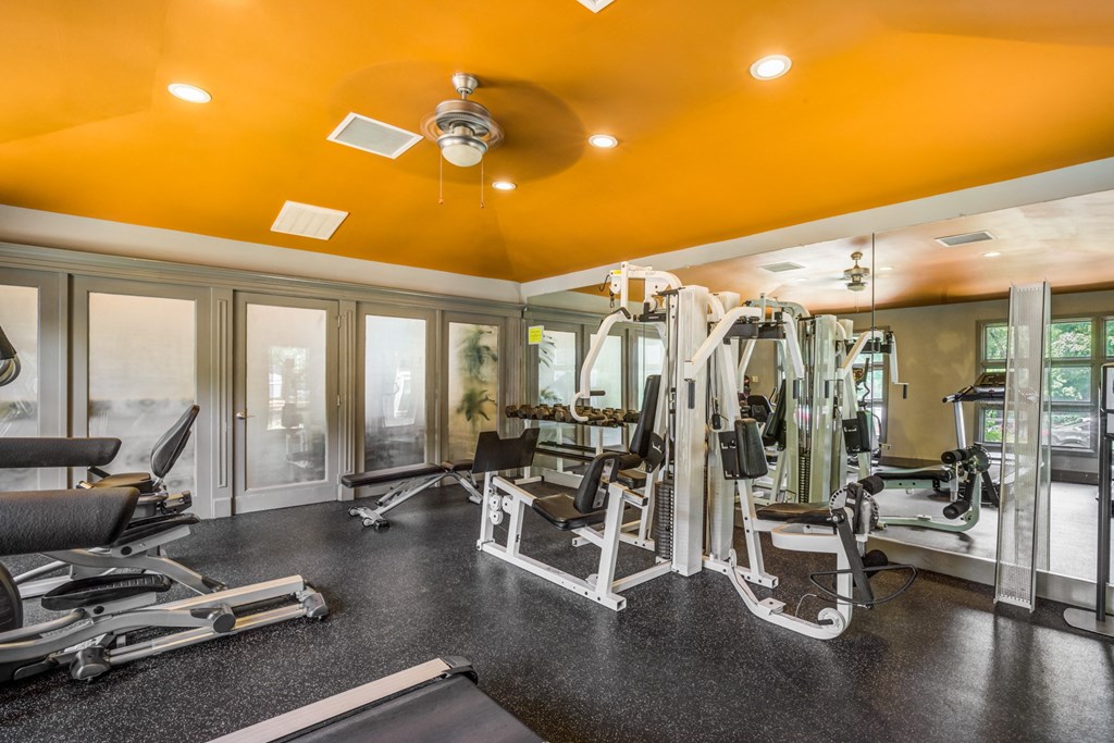 a gym with exercise equipment and a ceiling fan