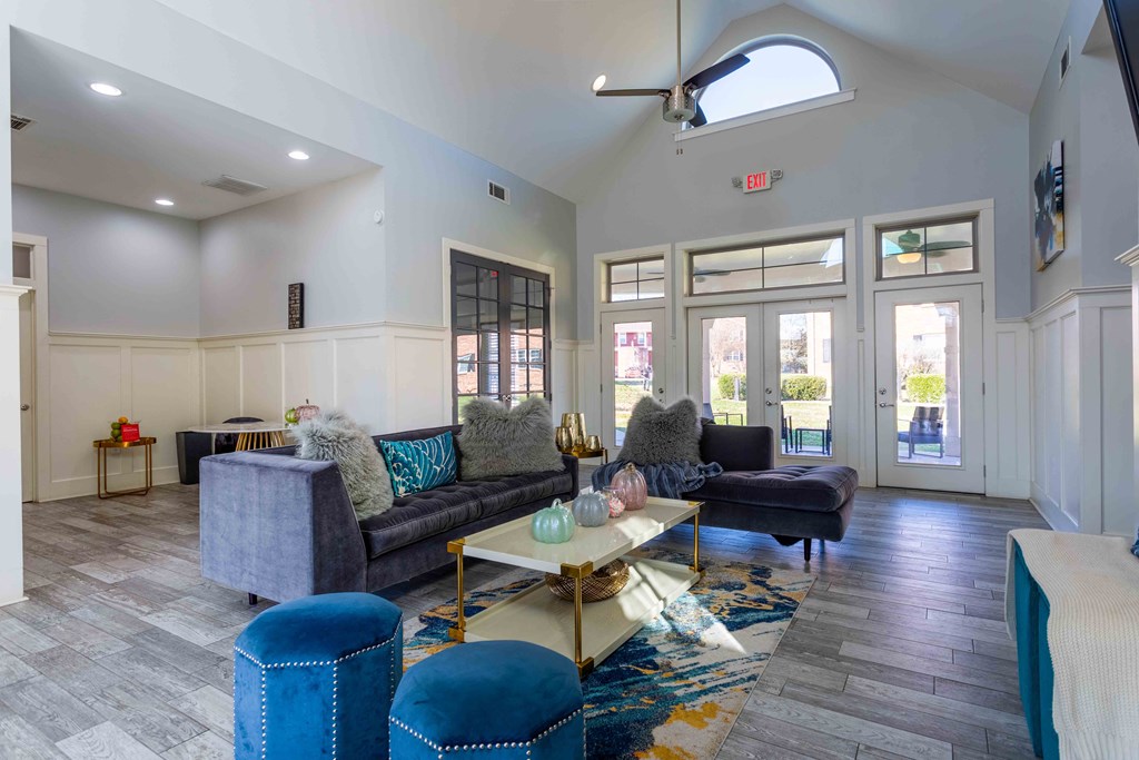 a living room with couches and chairs and glass doors