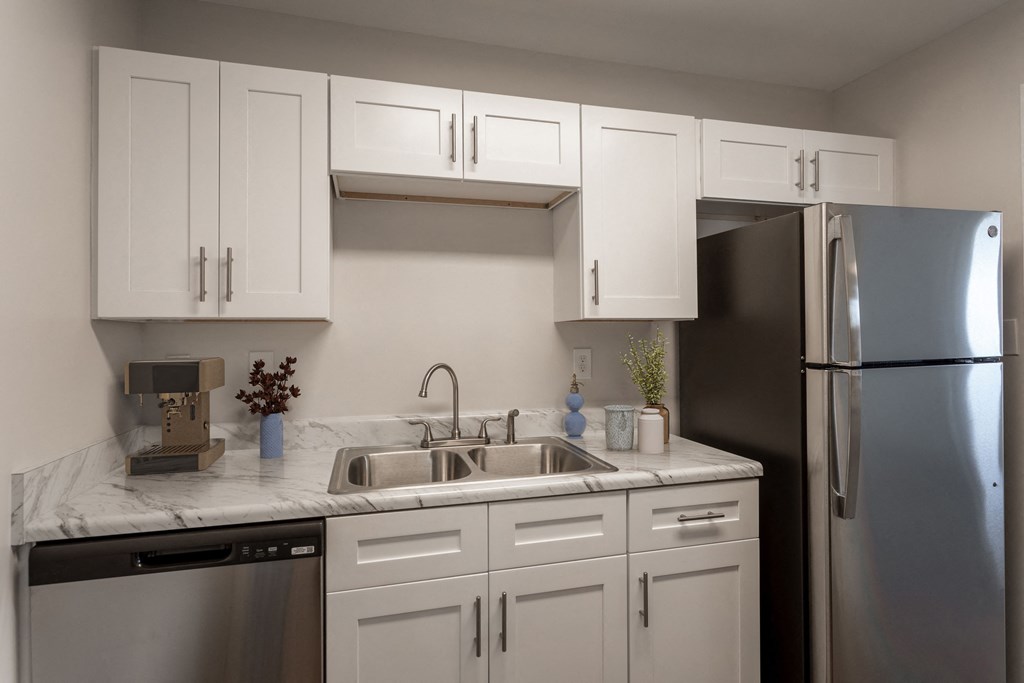 a kitchen with white cabinets and a stainless steel refrigerator