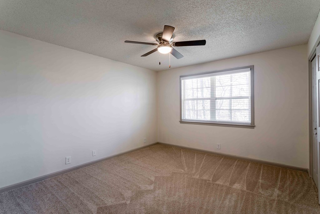 a bedroom with a ceiling fan and a window
