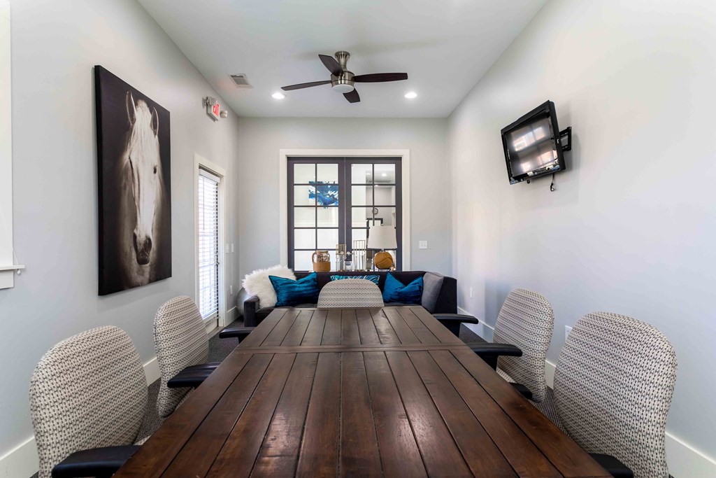 a dining room with a long wooden table and a ceiling fan