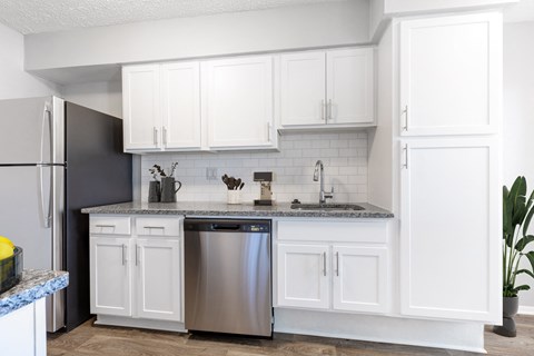 a white kitchen with stainless steel appliances and white cabinets