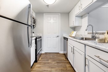 Reserve at Providence Apartment in Charlotte NC photo of a kitchen with white cabinets and stainless steel appliances - Photo Gallery 6