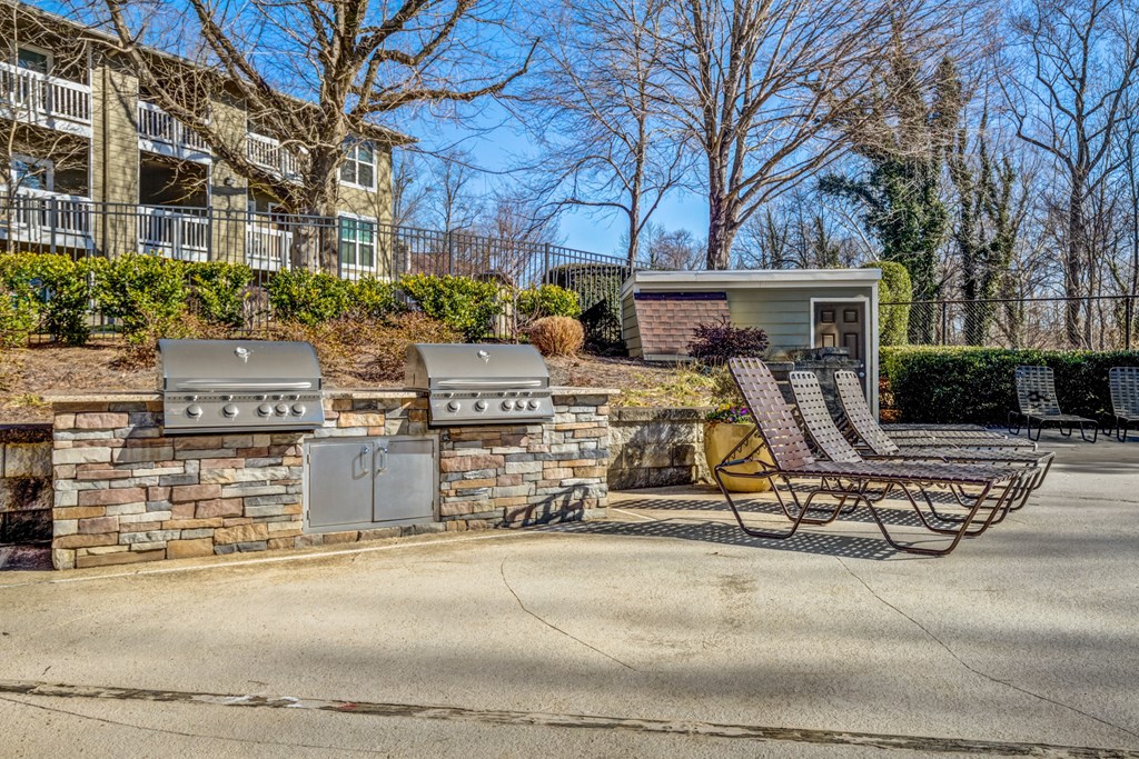 Two BBQ grills with lounge chairs at Reserve at Providence apartments in Charlotte near Matthews, NC