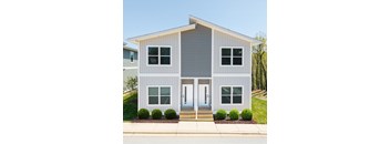 A two-story house with a grey exterior and white trim.