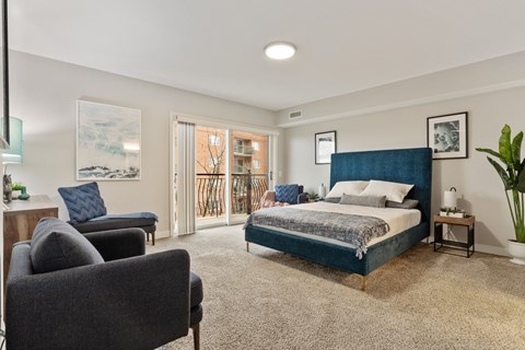 Spacious primary bedroom with wood-style flooring and natural light at River 595
