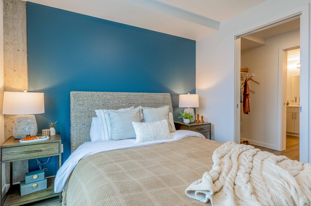 a bedroom with a bed and a blue wallat Riverfront Everett, Everett, WA, 98101