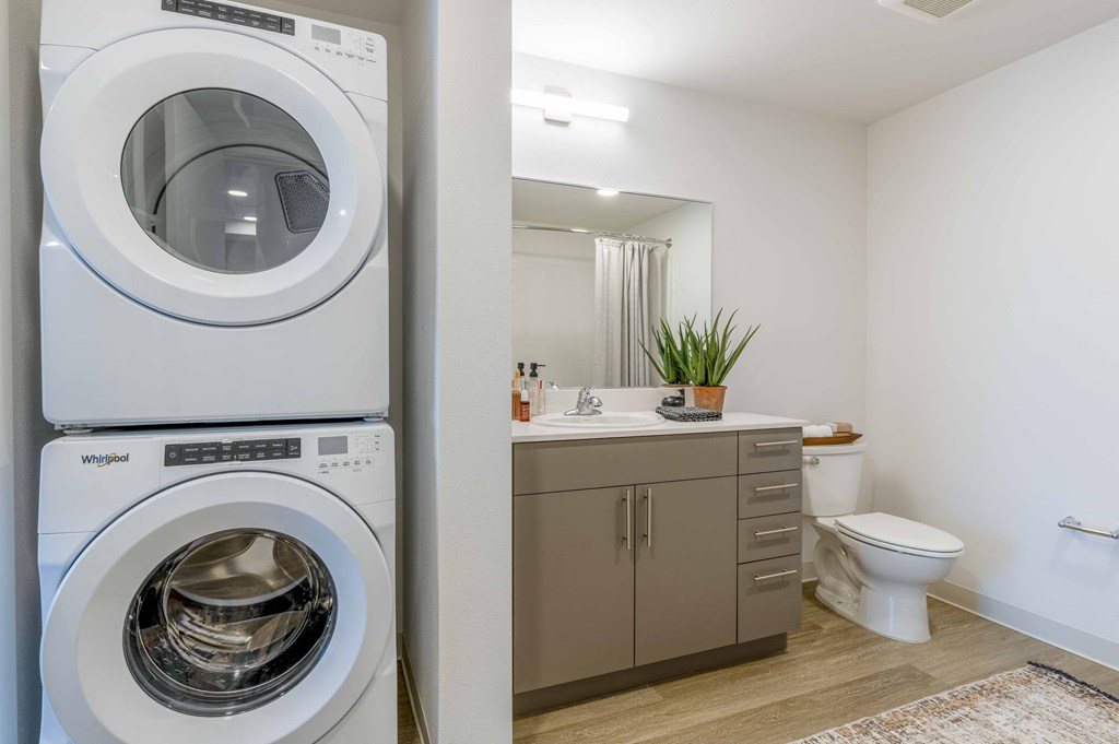 a white washer and dryer in a bathroom with a sink and toilet at Riverfront Everett, Everett
